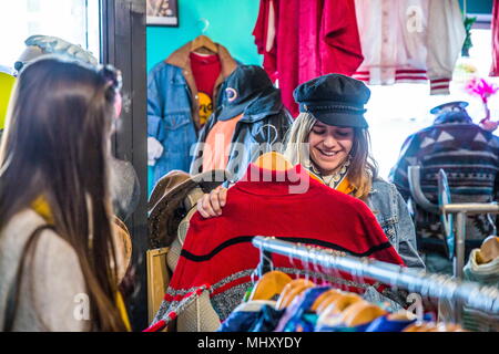 Friends browsing vintage clothes in thrift store Stock Photo