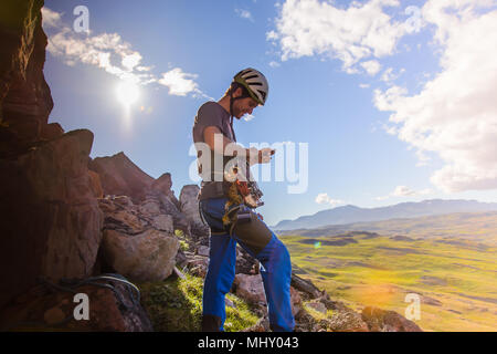 Young male climber preparing to climb, Narsaq, Vestgronland, South Greenland Stock Photo