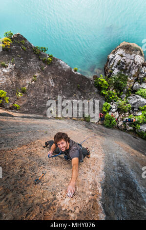 Man rock climbing on limestone rock, overhead view, Ha Long Bay, Vietnam Stock Photo