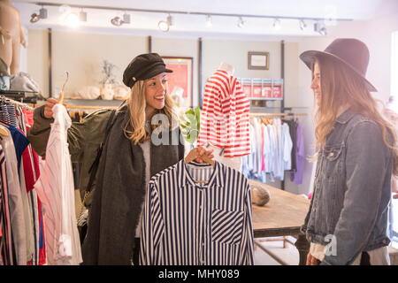 Two female friends, looking at clothes in shop Stock Photo