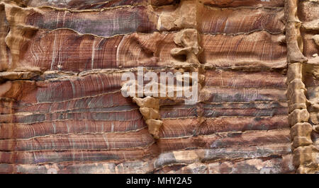 Laminated sandstone in Petra, Jordan, with strong red, yellow, orange and brown colours, middle east Stock Photo