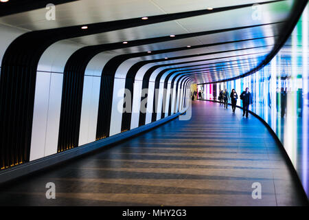 Underground pedestrian tunnel featuring colourful everchanging lighting. The tunnel links Kings Cross Underground station to the St Pancras Square office developments. Stock Photo