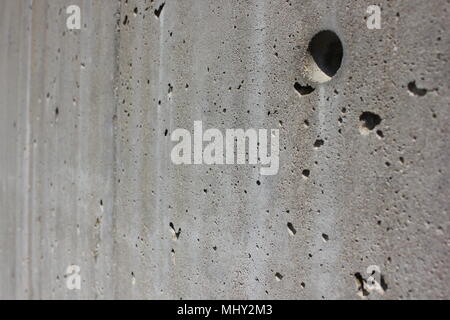 Close up view of an exterior poured in place concrete wall complete with form textures and holes. Stock Photo