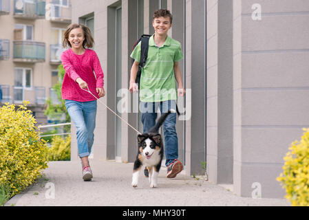 Teen boy and girl playing with puppy Stock Photo