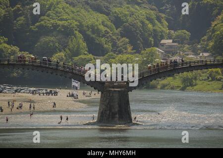 U.S. service members and Japanese locals walk over the Kintai Bridge during the Daimyo Procession Kimono Costume Parade in Iwakuni City, Japan, April 29, 2018, April 29, 2018. The parade was featured in the 41st Annual Kintai Bridge Festival. This parade was originally held as a religious service when the former Iwakuni castle lord, or Jyoshu, came to greet the townspeople. Presently, it's a local tourist attraction that draws an estimated 40, 000 people annually. (U.S. Marine Corps photo by Lance Cpl. Stephen Campbell). () Stock Photo