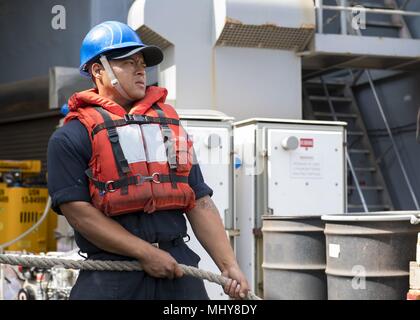 180430-N-TJ319-0293 AQABA, JORDAN (April 30, 2018) Seaman Recruit William Castro mans a line on the boat deck of the Harpers Ferry-class dock landing ship USS Oak Hill (LSD 51) April 28, 2018, April 30, 2018. Oak Hill, home-ported in Virginia Beach, Virginia, is in the U.S. 5th Fleet area of operations participating in Eager Lion, a capstone training engagement that provides U.S. forces and the Jordan Armed Forces an opportunity to rehearse operation in a coalition environment and to pursue new ways to collectively address threats to regional security and improve overall maritime security. (U. Stock Photo
