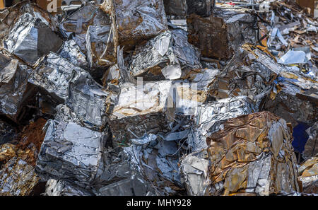 Scrap metal waste pressed into blocks at a processing plant. Stock Photo