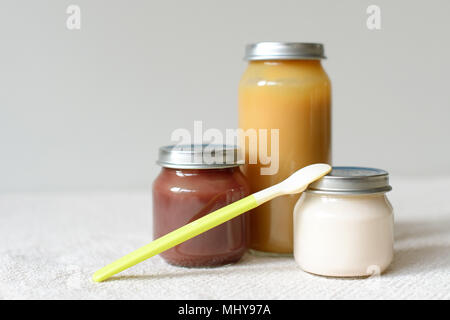 Bowls of pureed food with spoon for baby over blurred background Stock Photo