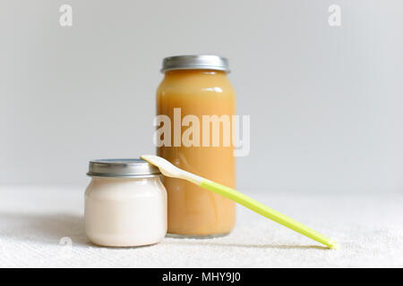 Bowls of pureed food with spoon for baby over blurred background Stock Photo