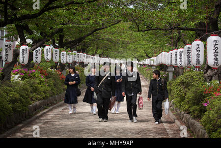 Young Japanese school children walking in a line holding hands in Ueno ...