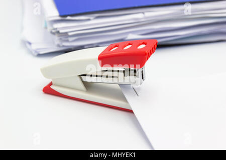 Pink stapler and paper document on white background, Office equipment. Stock Photo