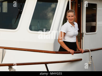 Young blond woman on board pleasure boat smiling.. Stock Photo