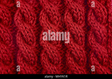 Detail of red handknit coiled rope cable knitting stitch as abstract background Stock Photo