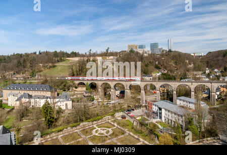 Train on viaduct in Luxembourg against background of European organisations buildings Stock Photo