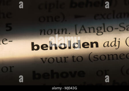 beholden word in a dictionary. beholden concept Stock Photo - Alamy