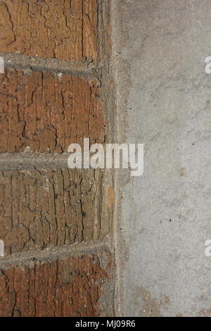 Closeup view of an architectural detail of a brick wall joined with a stone wall. Stock Photo