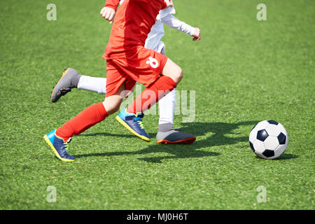Child soccer players and ball on the football field Stock Photo