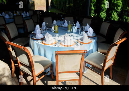 Served for a banquet catering table with wine glasses and plates for food Stock Photo