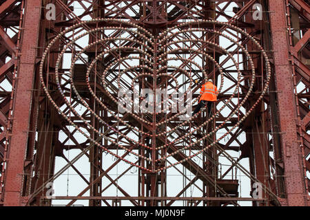 A maintenance workman repairing the lights on the fascia of Blackpool tower on the seafront promenade at Balckpool in Lancashire, UK. Stock Photo