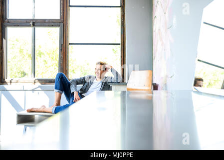 A young handsome male Dancer resting in a modern Loft Apartment Stock Photo