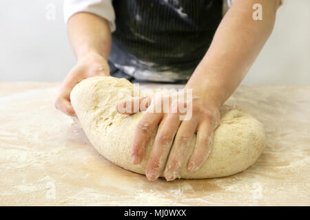 Making dough by male hands at bakery Stock Photo