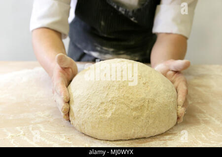 Making dough by male hands at bakery Stock Photo