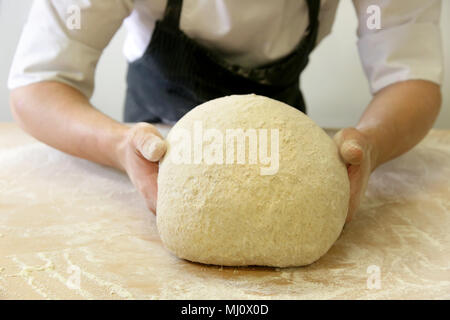 Making dough by male hands at bakery Stock Photo
