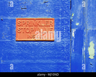 sprinkler stop valve inside sign orange on blue building background Stock Photo
