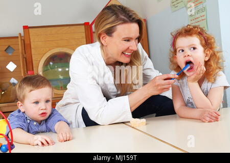 A Dentist brushing teeth in Kindergarten Stock Photo