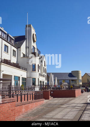 Looking up the terrace at the rear of the Carnoustie Golf Hotel at Carnoustie Golf Links, with Golfers sitting down enjoying a drink. Angus, Scotland. Stock Photo