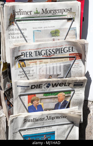 BERLIN - APR 28, 2018: Newspaper stand with various German newspapers and Angela Merkel and Donald Trump on the front cover of Die Welt newspaper. Stock Photo