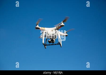 Drone in flight against blue sky Stock Photo