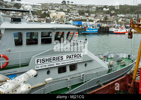 The Fisheries Patrol vessel, Saint Piran, in the foreground with fishing boats and the town of Newlyn in the background. Stock Photo