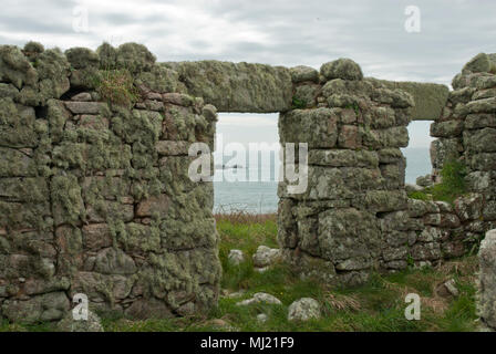 Remnants of a house covered in lichen on the now uninhabited Island of Samson, the sea can be seen through the door and window. isles of Scilly. Stock Photo