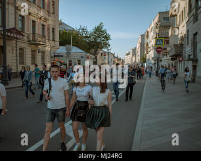 MOSCOW, RUSSIA - MAY 9, 2016: A skinhead with two girls are walking along Bolshaya Ordynka Street after the march Immortal Regiment. Looks at the came Stock Photo