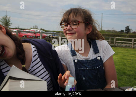 Sisters Playing About Sitting at Table outside Gillingham Dorset England Stock Photo