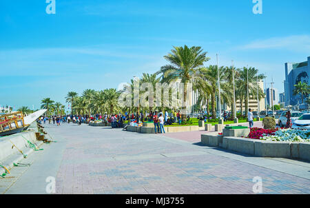 DOHA, QATAR - FEBRUARY 13, 2018: Numerous migrant workers like to spend their day off in Corniche promenade, men have picnics, relax in shade or take  Stock Photo