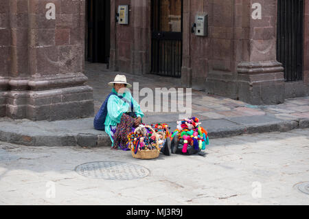 Sierra Otomi Indian woman in straw hat selling colorful handmade children's dolls and toys Stock Photo