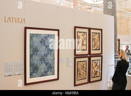 03 May 2018, Latvia, Riga: A visitor examines patterns and sketches of the Latvian artist Julijs Straume (1874-1970) at the art museum of Riga's stock exchange. An exhibition showcasing art nouveau items will run until 5 August and present around 200 pieces from the art historical period around 1900. Photo: Alexander Welscher/dpa Stock Photo