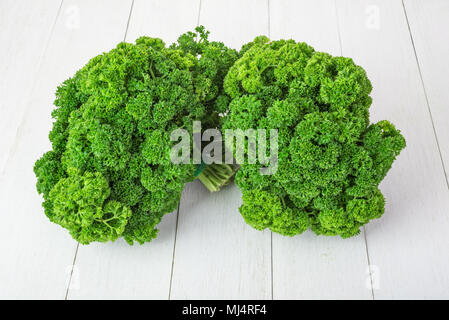 fresh green curly parsley on  white wooden background Stock Photo