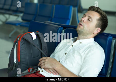 Caucasian man is sleeping in lounge area at the airport. Stock Photo