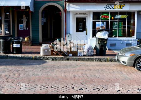 Trash and recycling piled up on the sidewalk outside a subway restaurant in Annapolis, MD, USA Stock Photo