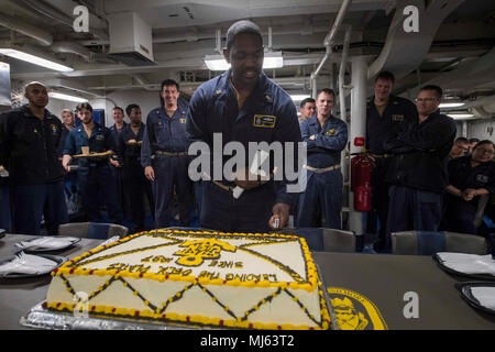 OCEAN (April 1, 2018) Chief Engineman Walter Williams, assigned to Whidbey Island-class dock landing ship USS Rushmore (LSD 47), cuts a cake in celebration of the Navy Chief’s 125th birthday during an amphibious squadron and Marine expeditionary unit (MEU) integration (PMINT) exercise. PMINT is a training evolution between Essex Amphibious Ready Group and 13th MEU, which allows Sailors and Marines to train as a cohesive unit in preparation for their upcoming deployment. (U.S. Navy Image collection celebrating the bravery dedication commitment and sacrifice of U.S. Armed Forces and civilian per Stock Photo