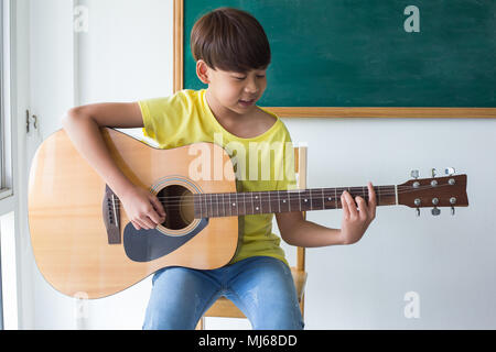 Young boy with an acoustic guitar Stock Photo