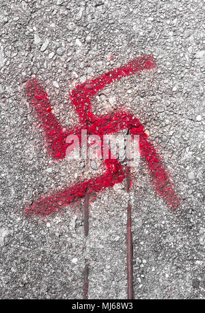 Graffiti on road floor of the svastika symbol. Stock Photo