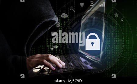 Internet network security system. Hacker in black hoodie using computer laptop and technology lock and application icons Stock Photo