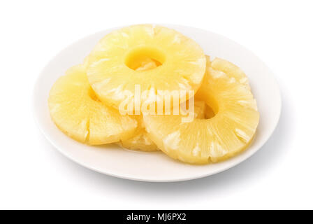 Canned pineapple slices on plate isolated on white Stock Photo