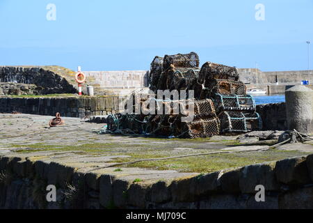 Creels and lifebuoy stored on quay at Portsoy Old Harbour, Aberdeenshire, Scotland Stock Photo