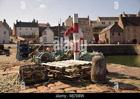 Creels and lifebuoy stored on quay at Portsoy Old Harbour, Aberdeenshire, Scotland Stock Photo