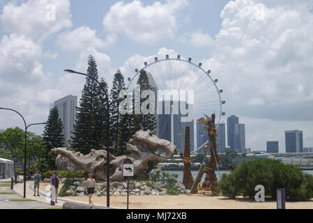 Singapore / Singapore - April 9 2018: Tourists are visiting the Gardens by the Bay in Singapore walking alongside the Marina with the ferris wheel 'Si Stock Photo